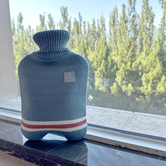 Blue OliviaLiving Classic 2L hot water bottle on a windowsill for a microwave safety guide